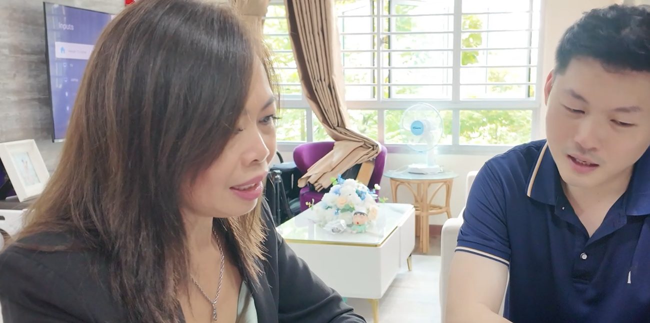 Esther Ng going through affordability figures with a client at his dining table
